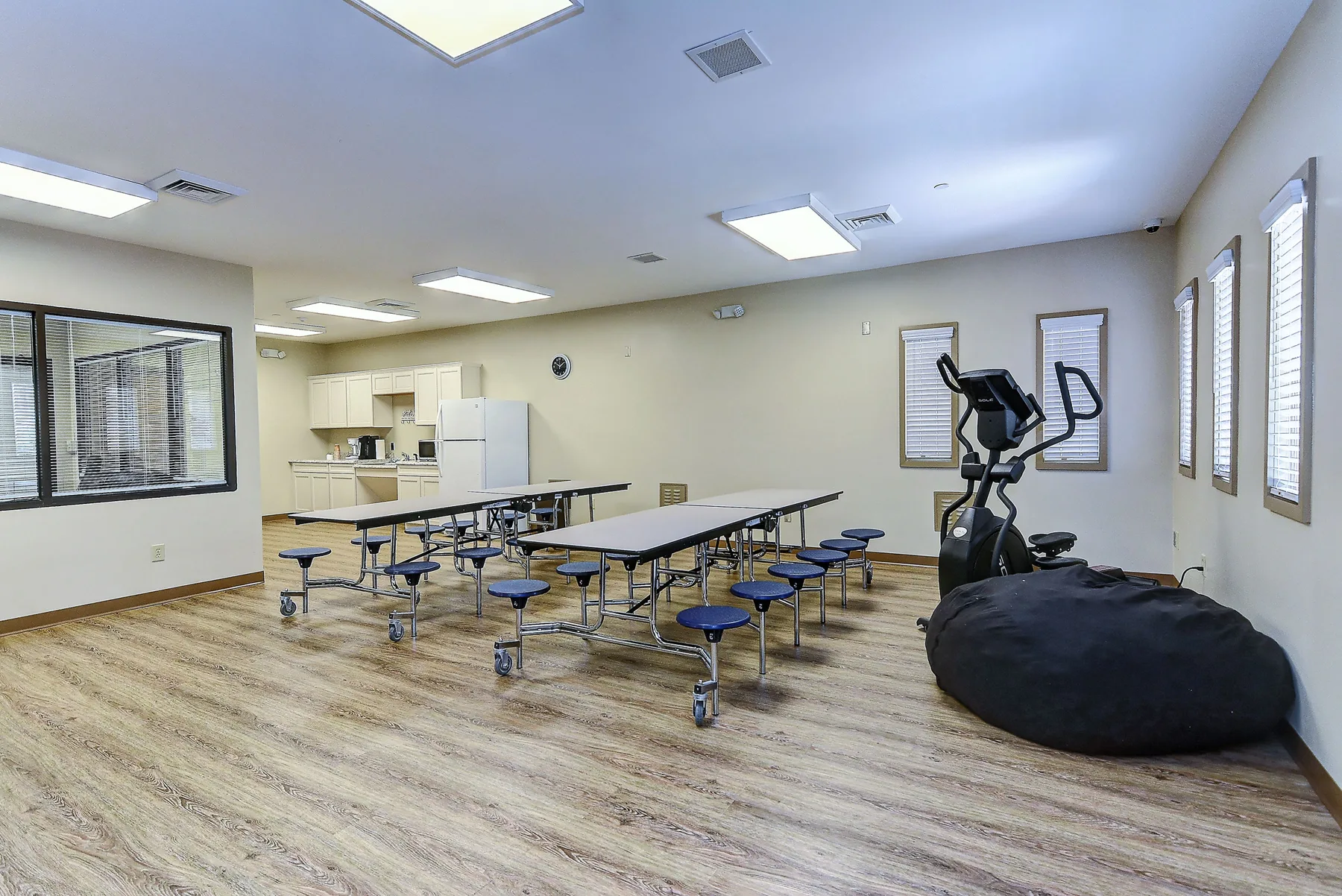 Dining tables and exercise machine in a bright room at Freedom Detox
