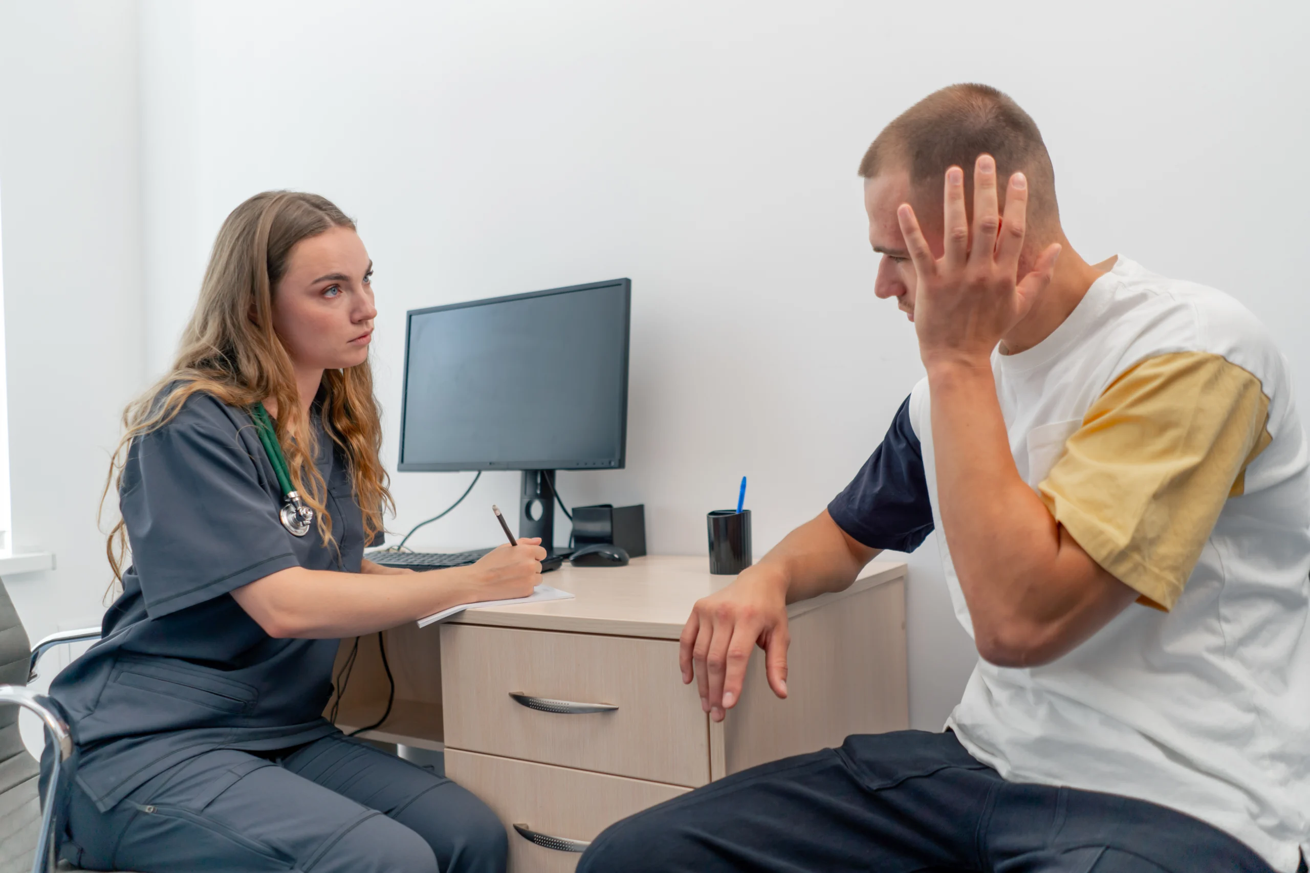 Patient sitting with healthcare provider in office discussing symptoms