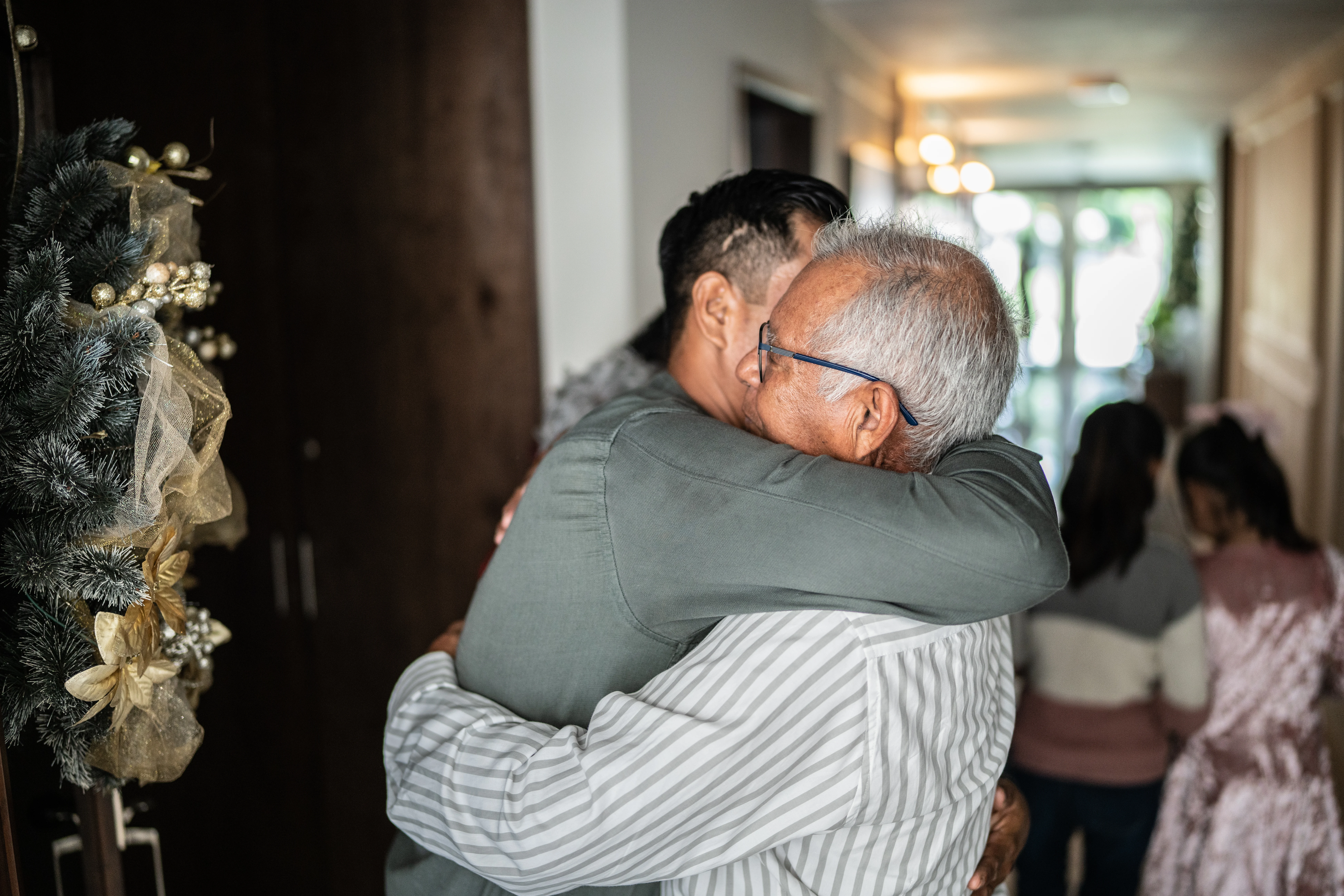 Son greeting father on christmas at home