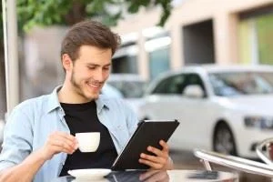 Man reading an ebook on a tablet at a coffee cafe