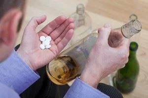 Man mixing pills with alcohol