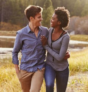 multiracial couple walking through a park