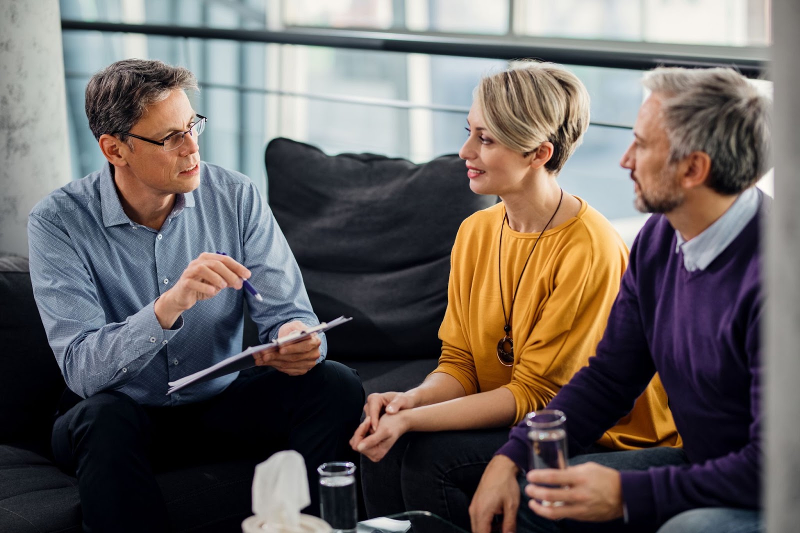 An adult couple sitting in a counseling session sitting on the couch