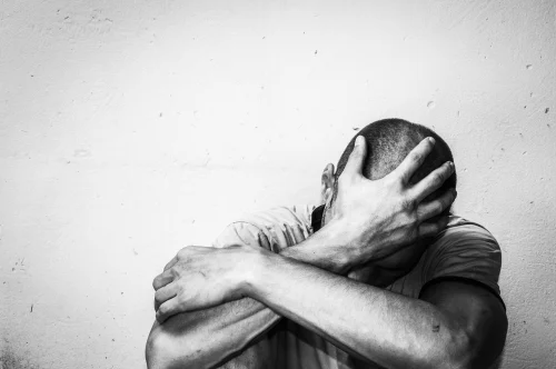 Distraught man with his hand covering his head/face