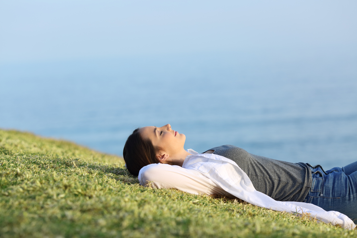 Relaxing woman on the hilly grass