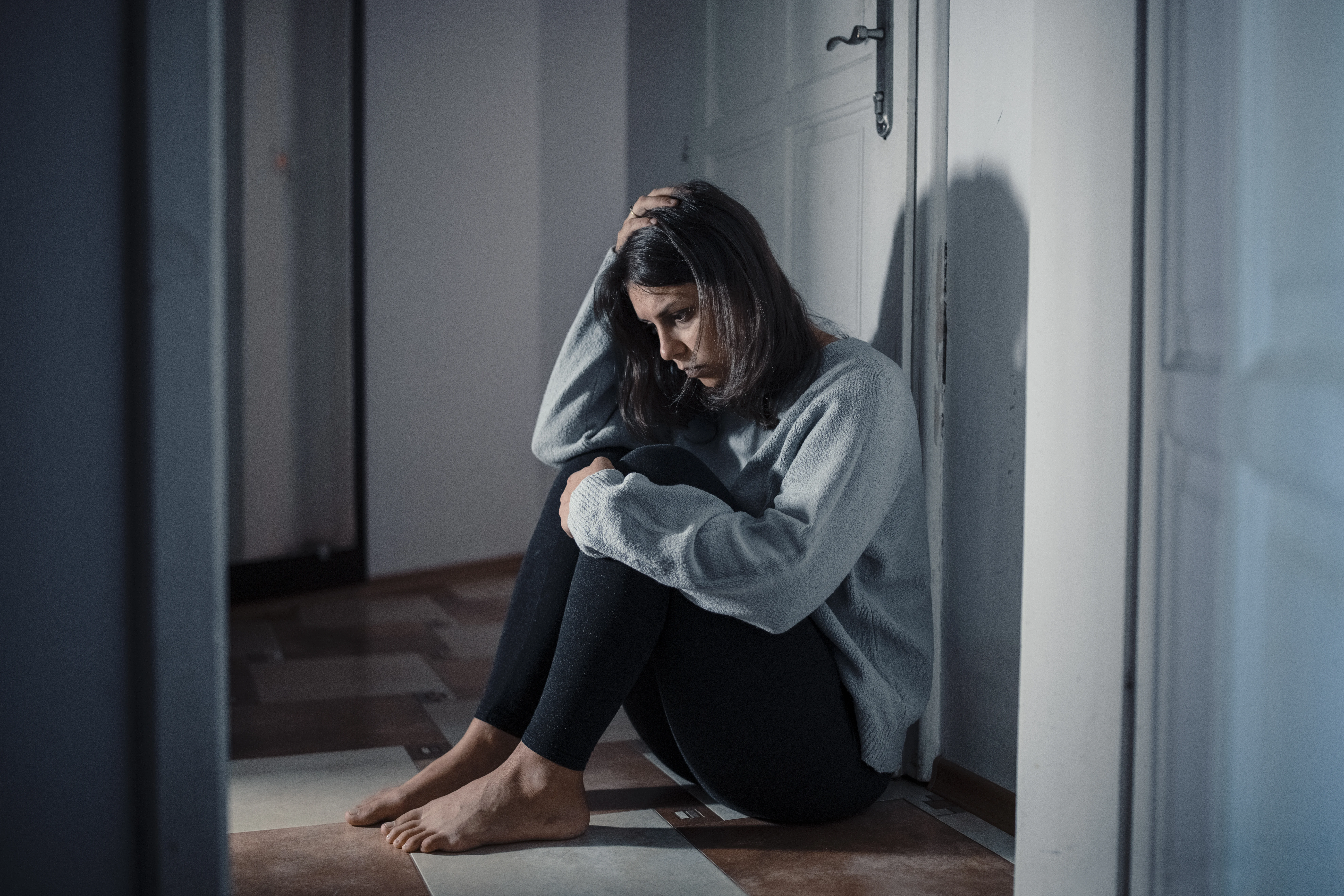 A sad woman sitting on the floor