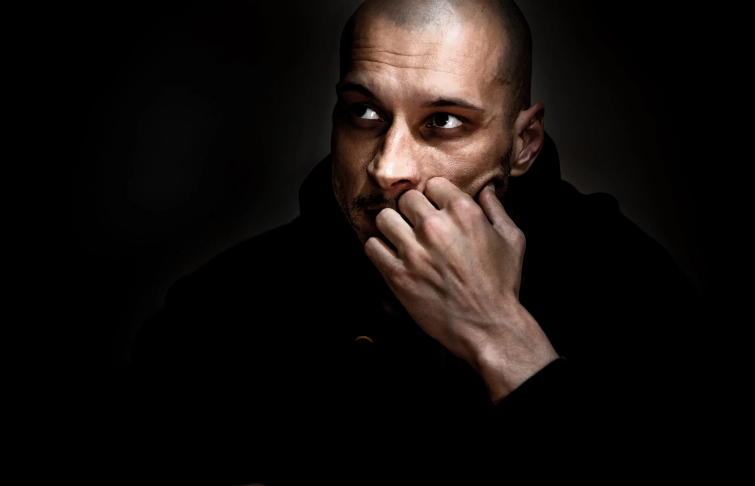 Nervous guy, Dramatic dark portrait with strong contrast and film grain of young man sitting in the room with sadness and depression in his eyes thinking about life