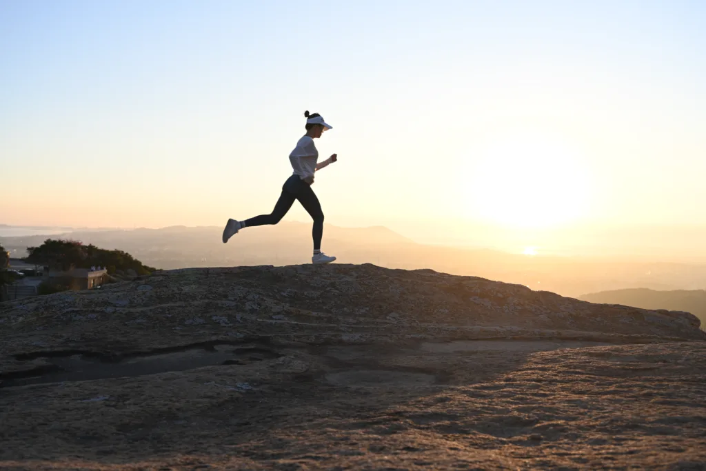 Chinese woman runs uphill in the mountains against the light